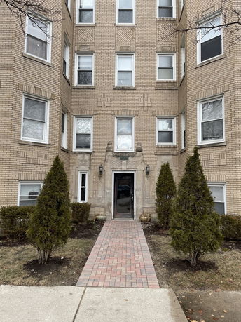 Front view of a multi-story brick building with a central entrance.