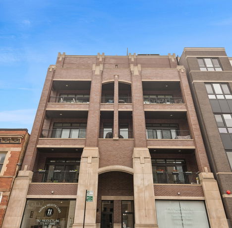 Front view of a multi-story brick building with balconies.