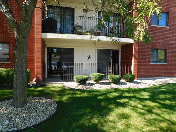 Front view of a brick residential building with a balcony.