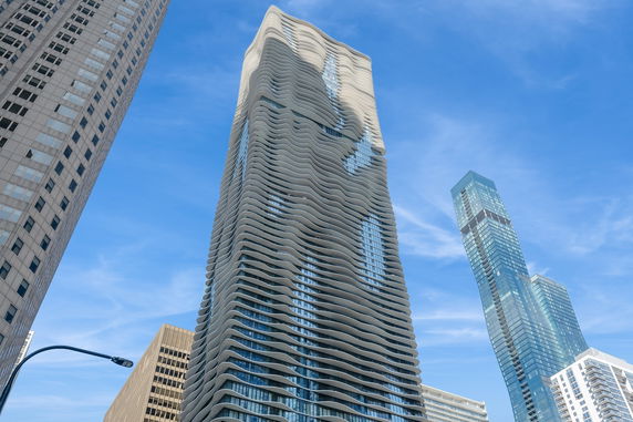 Elevation view of a modern high-rise building with a wavy, undulating facade.