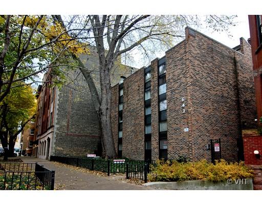 Front view of a multi-story brick building with vertical windows.