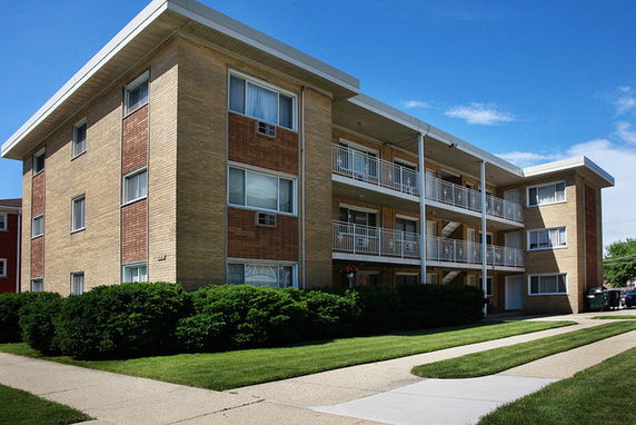 Front view of a three-story apartment building with balconies.