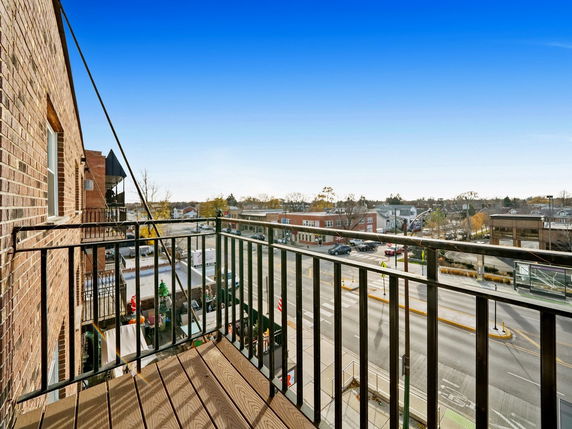 View from a balcony overlooking a street and buildings.