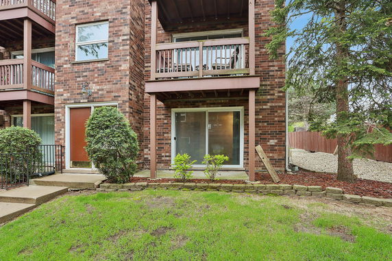 Front view of a multi-story brick apartment building with balconies.