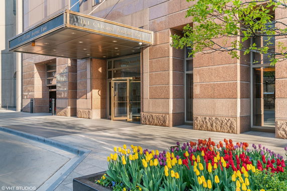 Front view of a building entrance with revolving doors and a canopy.