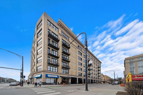 Front view of a multi-story commercial building with large windows and balconies.