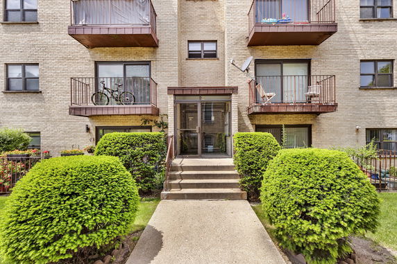 Front view of an apartment building with balconies and a central entrance.