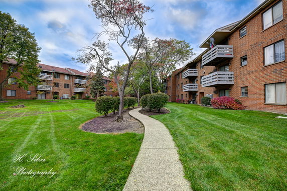 Front view of a multi-story brick apartment building with balconies.