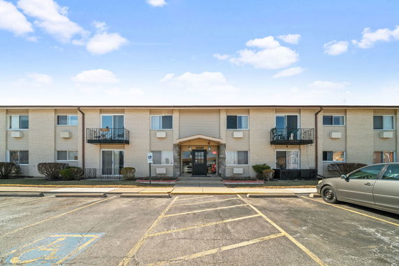 Front view of a two-story apartment building with balconies.