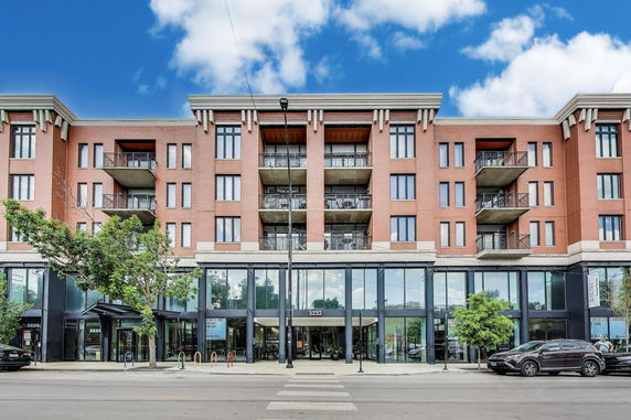 Front view of a multi-story brick building with balconies.