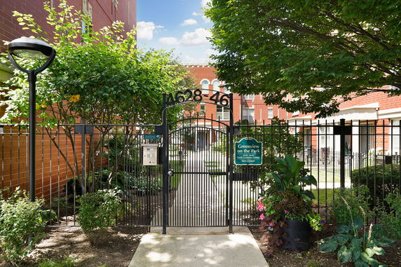 Front view of a brick building with a gated entrance.