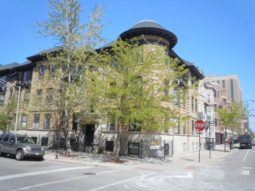Front view of a multi-story building with a rounded corner feature.