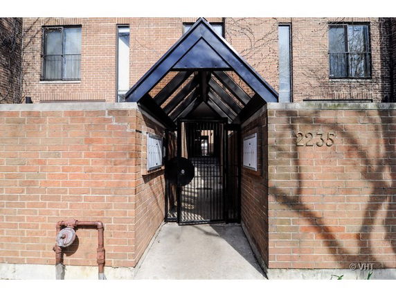 Front view of a building entrance with brick walls and a gated entryway.