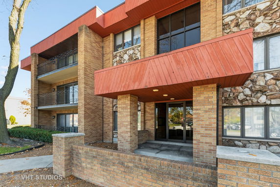 Front view of a multi-story building with a brick facade and balconies.
