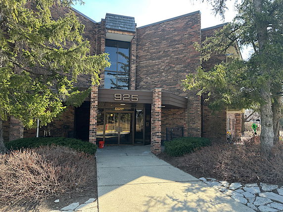 Front view of a brick office building with large glass windows and an entrance labeled 925.