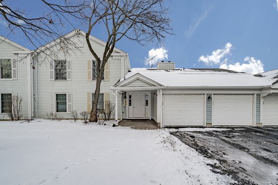 Front view of a two-story house with a double garage and snow-covered surroundings.