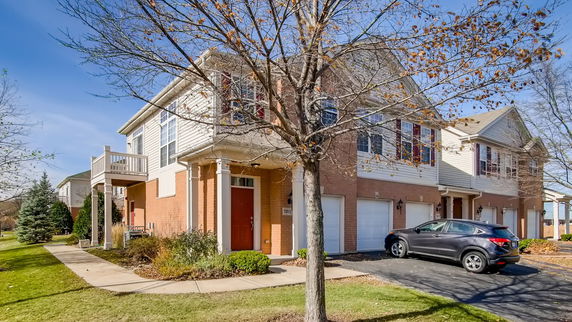Front view of a two-story residential building with garage and balcony.