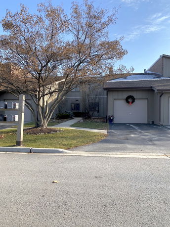 Front view of a house with a driveway and a single garage.