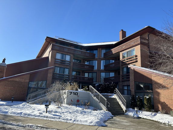 Front view of a large multi-story brick building with balconies and stair access.