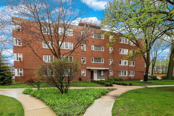 Front view of a four-story brick apartment building.