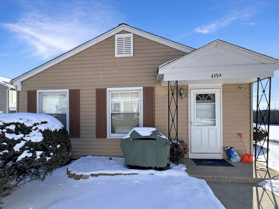 Front view of a single-story house with a covered entryway and two windows.