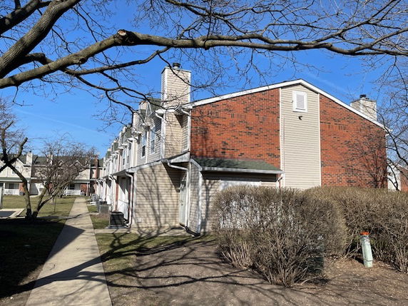 Front view of a two-story townhouse with a brick and siding exterior.