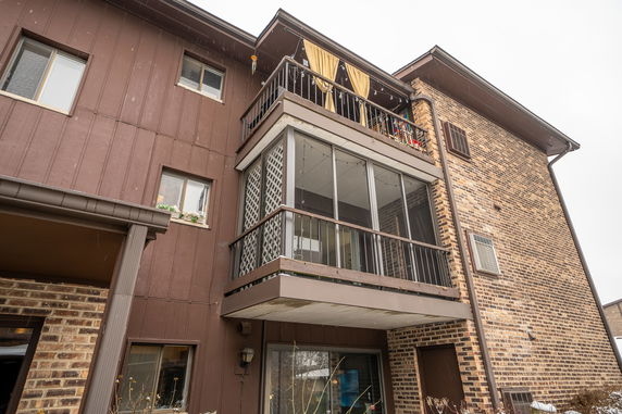 Front view of a multi-story building with balconies and brick facade.