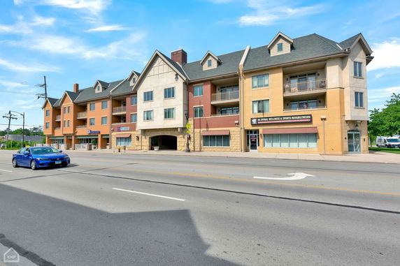 Front view of a multi-story building with commercial spaces on the ground floor.