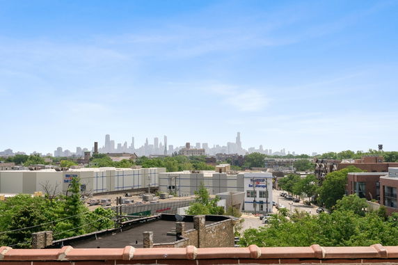 Panoramic view of a city skyline with buildings and trees in the foreground.