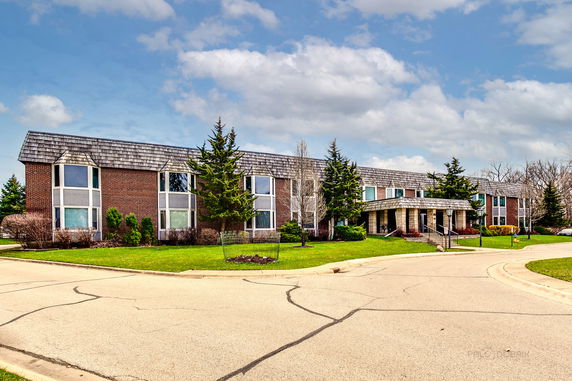 Front view of a large two-story building with brick exterior and multiple windows.