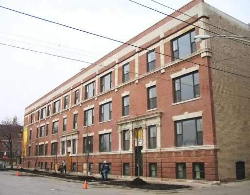 Front view of a multi-story brick building with multiple windows on each floor.
