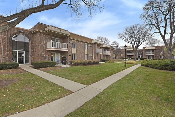Front view of a two-story brick apartment building with balconies.