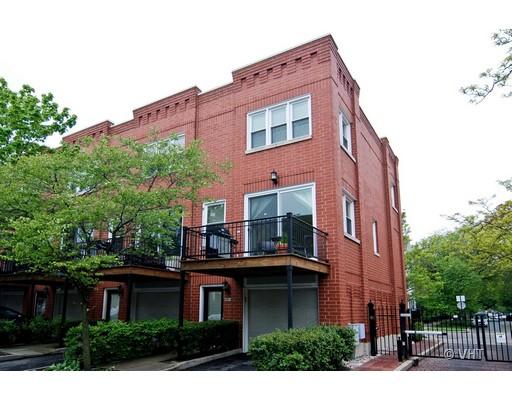 Front view of a three-story brick townhouse with balconies.