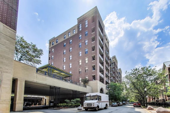 Front view of a multi-story brick apartment building with balconies.