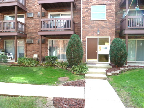 Front view of a multi-story brick building with balconies.