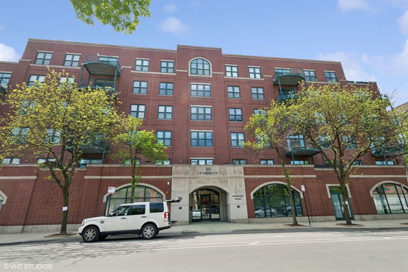 Front view of a multi-story brick building with arched entrances.