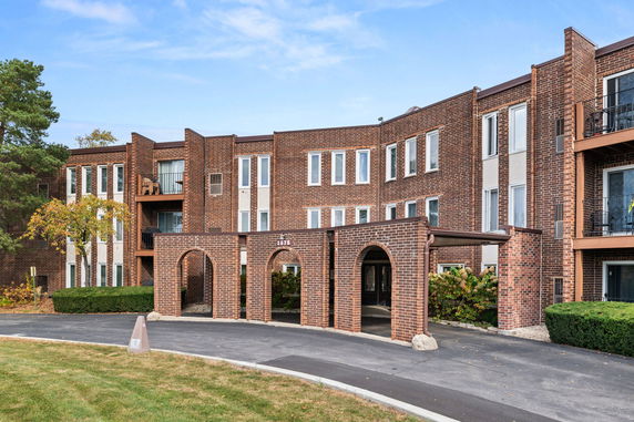 Front view of a multi-story brick building with arched entrances.