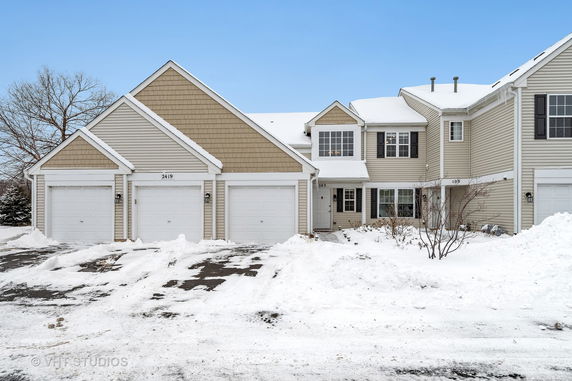 Front view of a house with attached garages in a snowy setting.