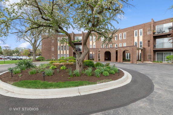 Front view of a multi-story brick building with arched entrances.