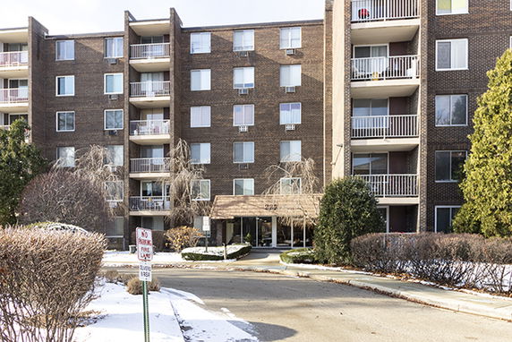 Front view of a multi-story apartment building with balconies.
