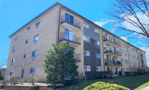 Front view of a multi-story apartment building with balconies.