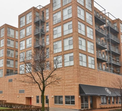 Front view of a multi-story brick building with balconies.