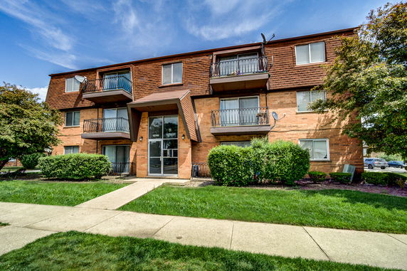 Front view of a three-story apartment building with balconies.