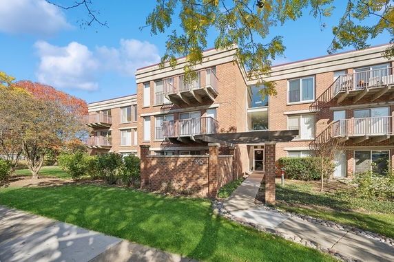 Front view of a three-story brick building with multiple balconies.