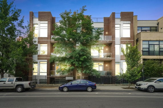 Front view of a modern multi-story apartment building with brick facade.