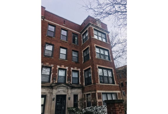 Front view of a multi-story brick building with multiple windows.