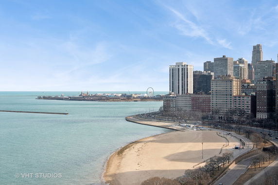 Panoramic view of a cityscape with tall buildings and a beach along the shoreline.