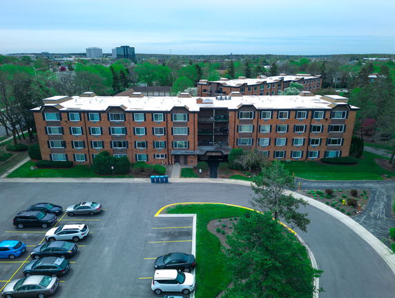 Front view of a multi-story residential building with a parking area.