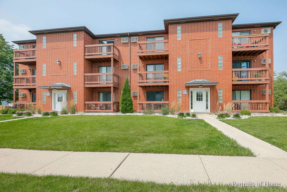Front view of a three-story brick apartment building.