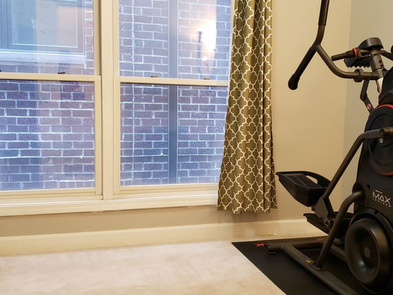 Interior view of a room with exercise equipment near a window.